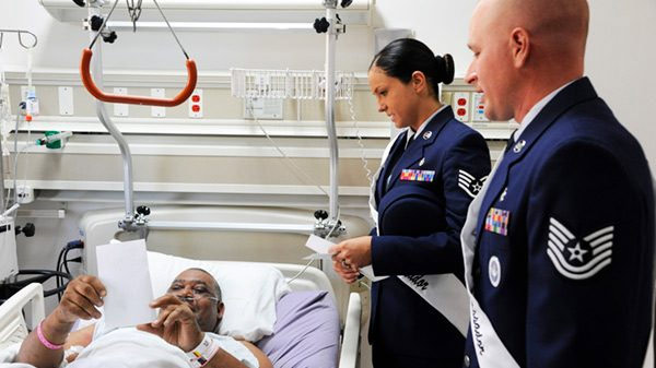 Two military officers visiting a soldier in the hospital
