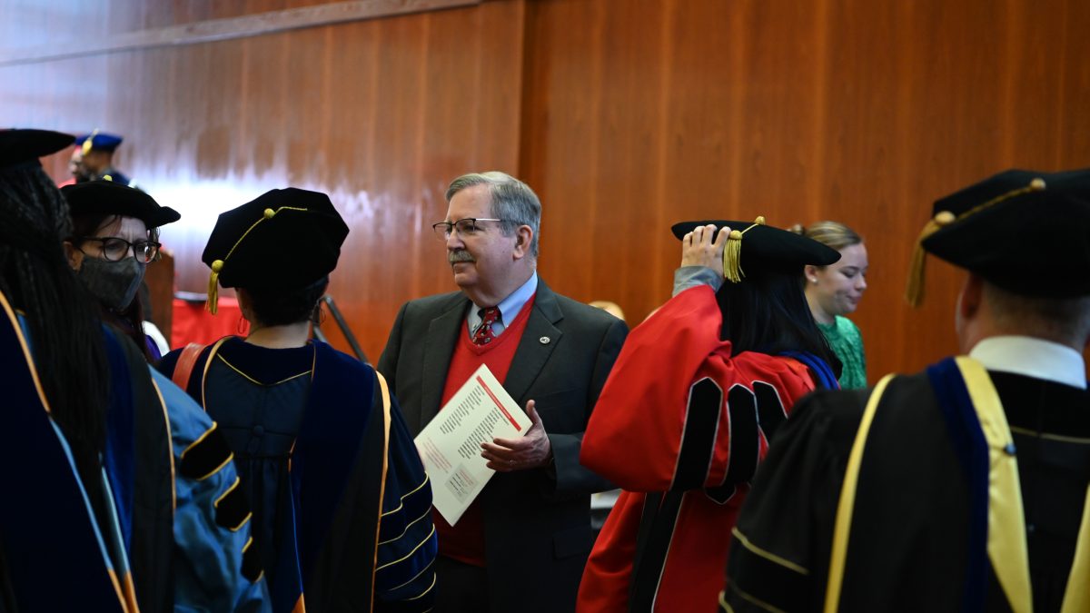 Paul Cohen talking with fellow faculty members after the graduation ceremony