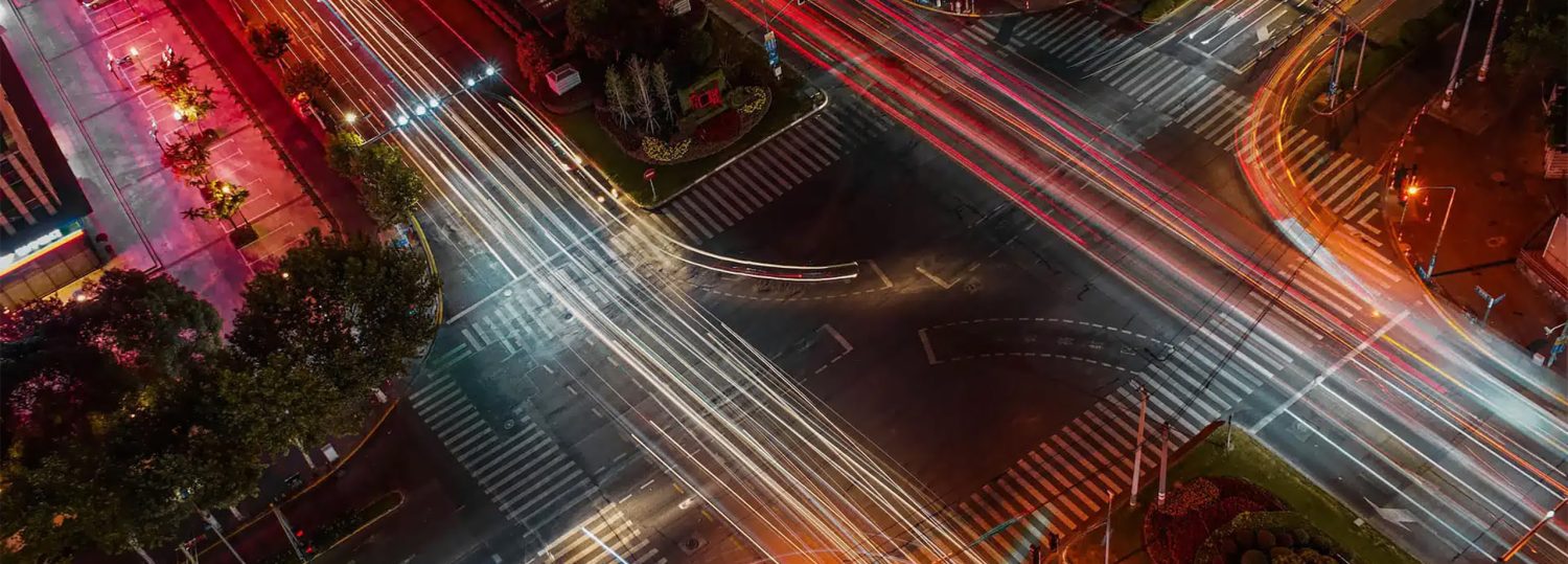 A time-lapse photo of a traffic intersection at night