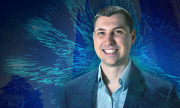 Cameron Lisy standing in front of a blue abstract background