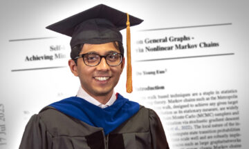 Vishwaraj Doshi in his graduation cap and gown standing in front of a giant version of his paper.