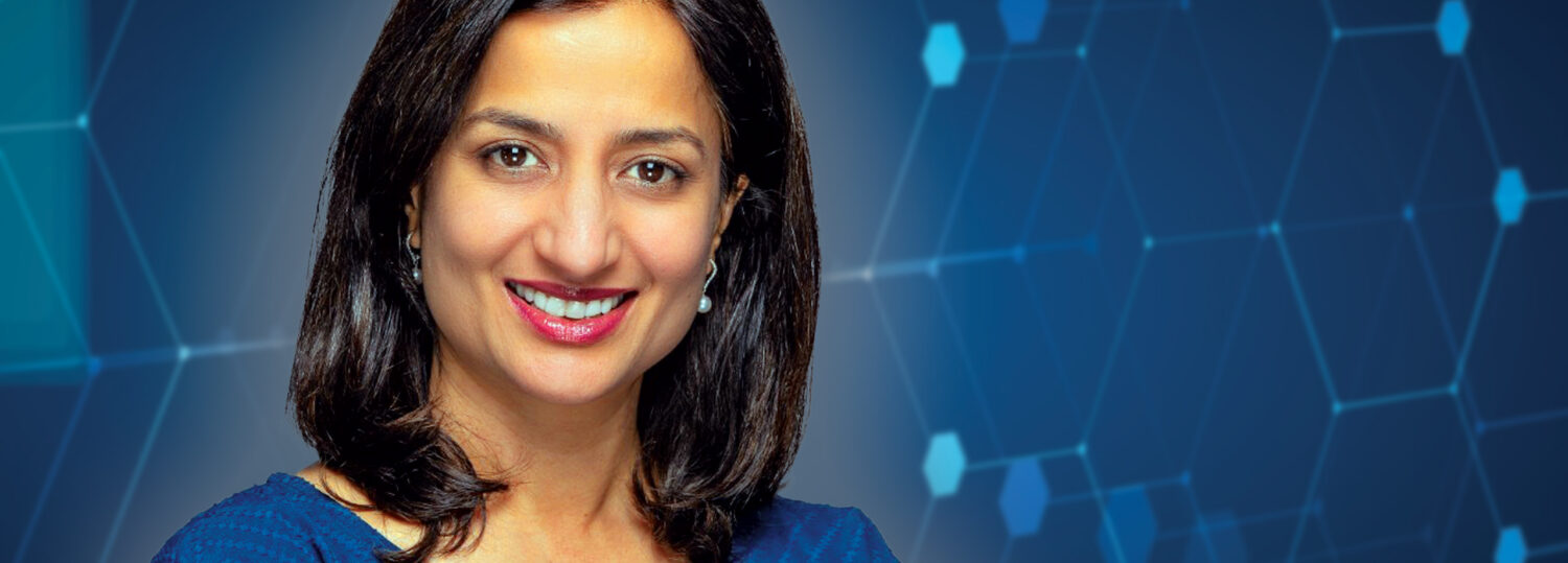 Varsha Damle in front of a technology-based blue background
