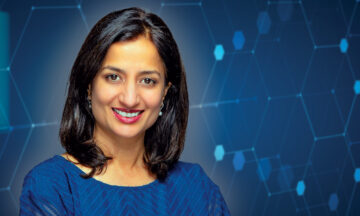 Varsha Damle in front of a technology-based blue background