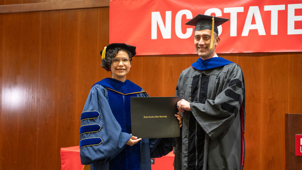 Ph.D. student Mathew Fukuzawa receives his degree from OR Director Maria Mayorga.
